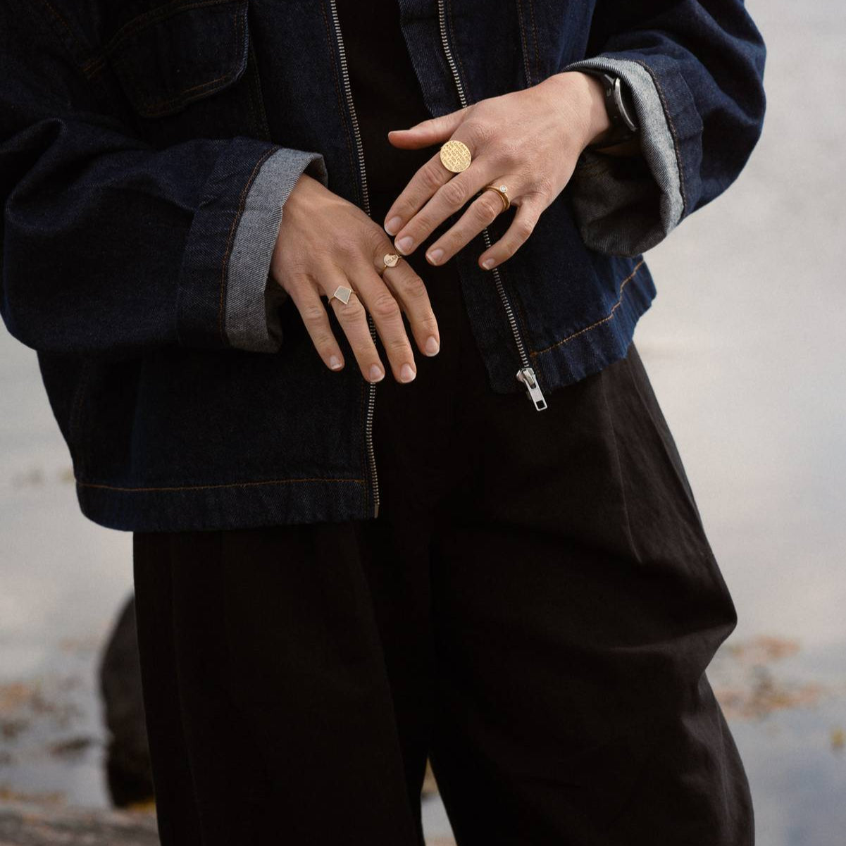 Person wearing the Shield of Faith Ring in 18K gold with a denim jacket.