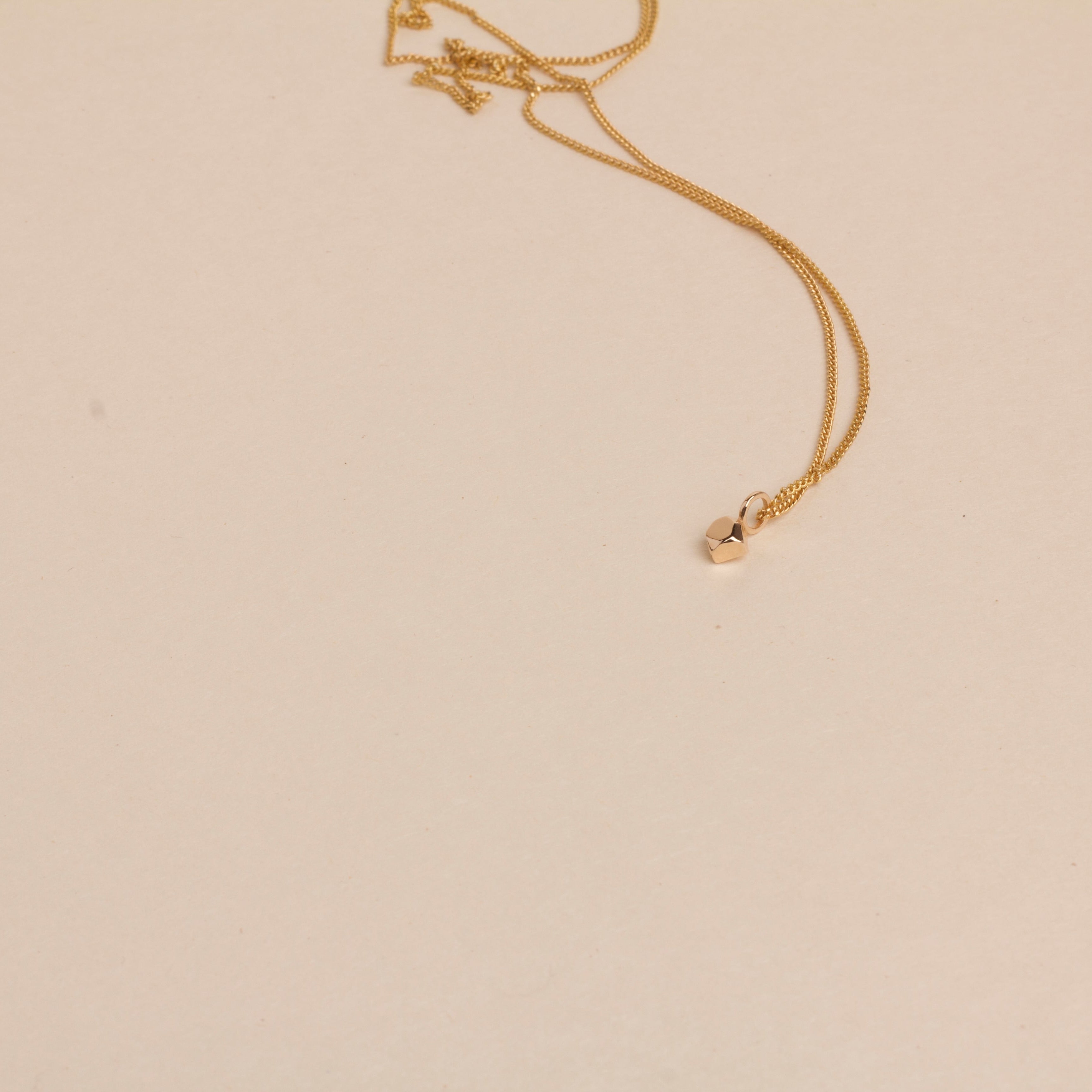 Gold necklace on a beige background