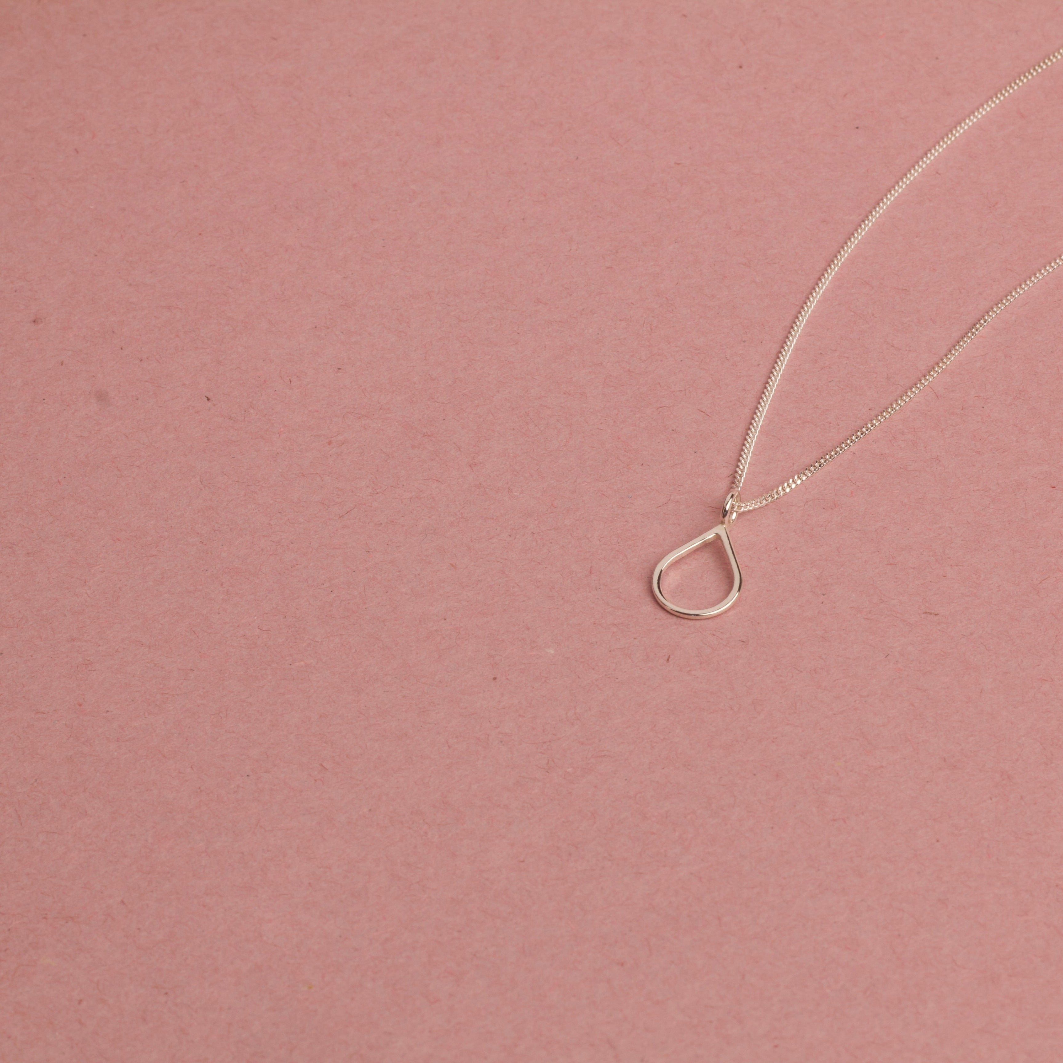 PS46 Jewelry Tears of Hope Open Pendant Necklace 18K White Gold displayed on a pink background