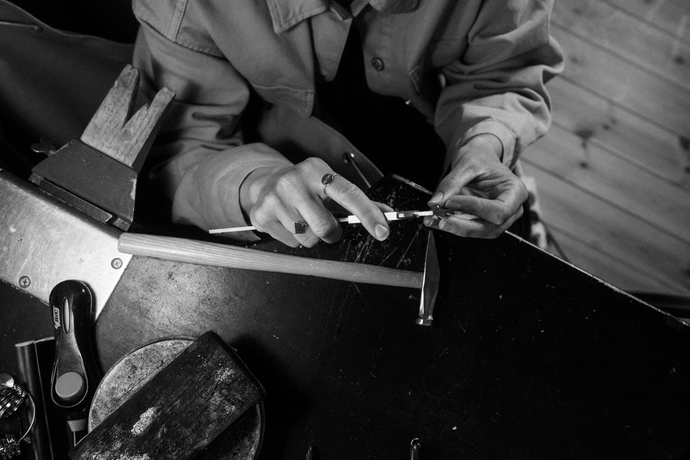 Person working with tools on a wooden surface, Emelie working on a jewelry design
