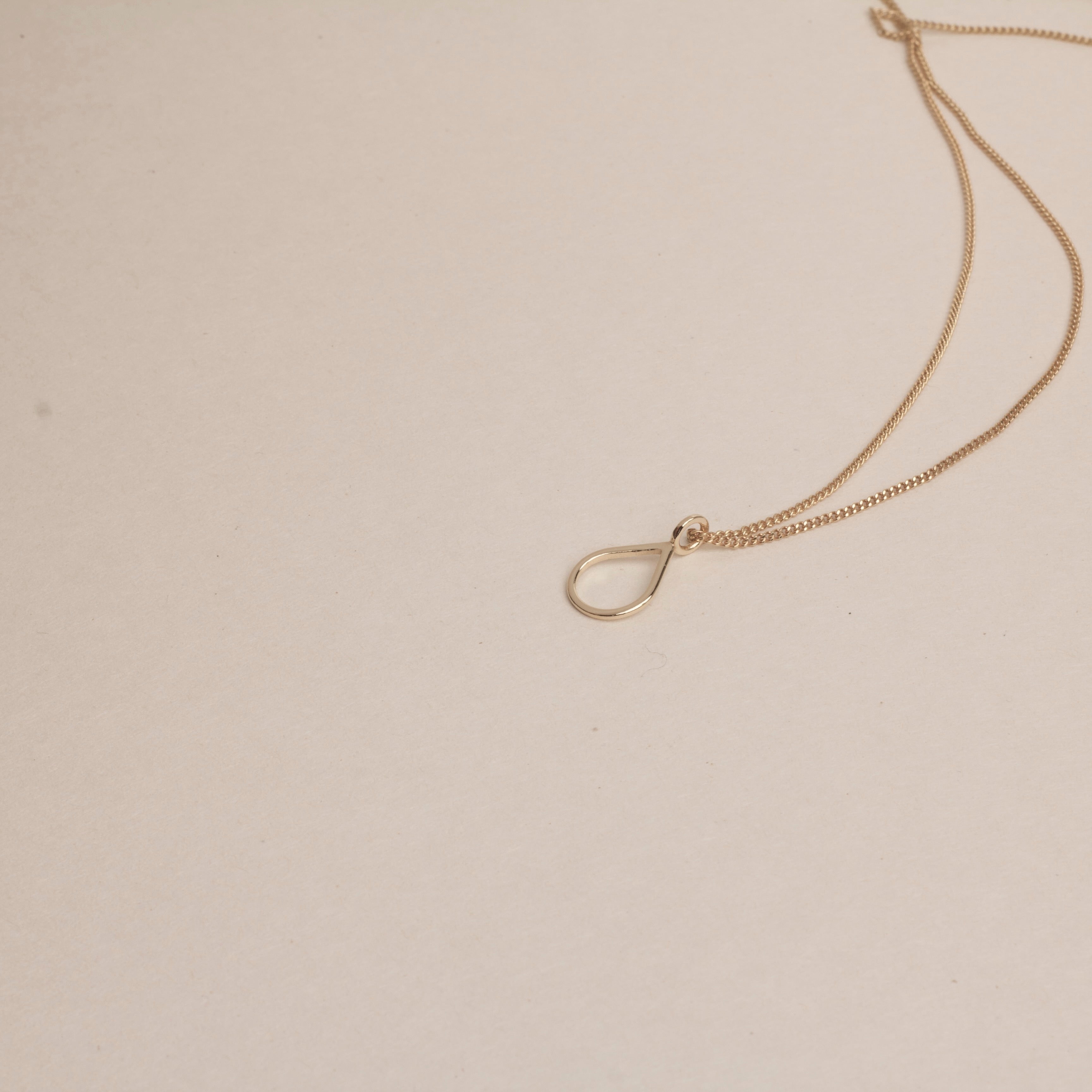 PS46 Jewelry Tears of Hope Open Pendant Necklace 18K Gold displayed on a beige background